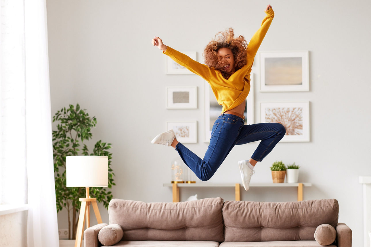 Frau springt auf dem Sofa