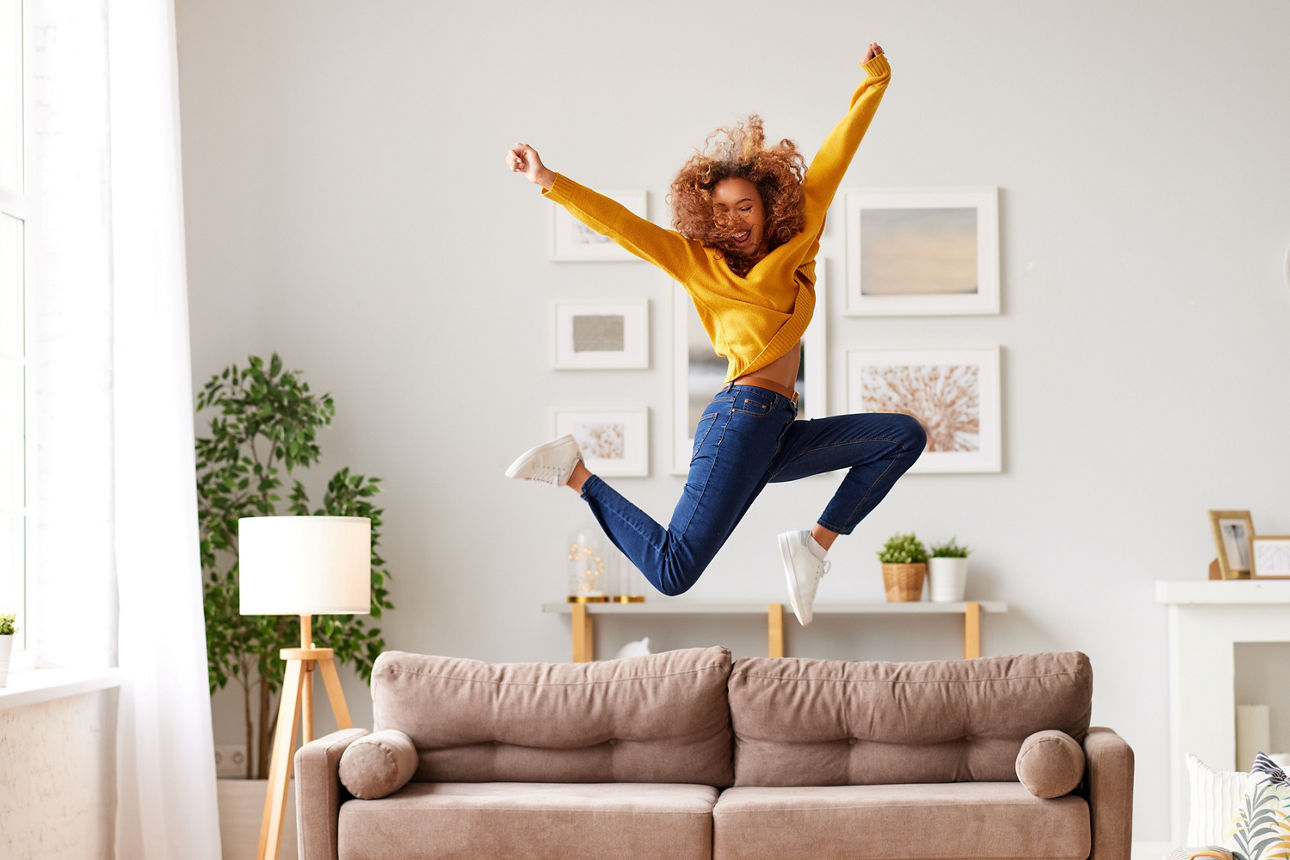 Eine Frau hüpft auf einem Sofa