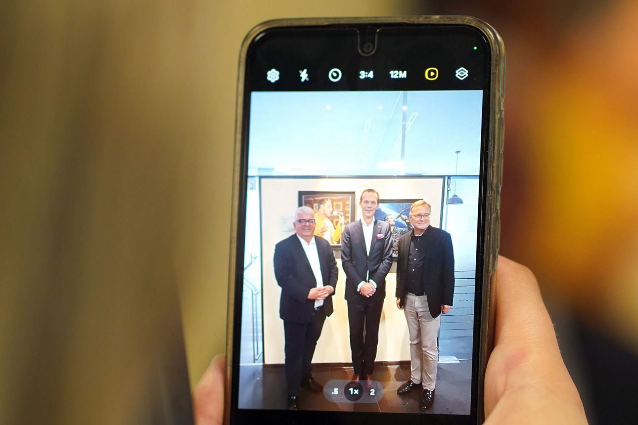 Besucherin der Ausstellung nimmt ein Foto mit Ihrem Smartphone auf