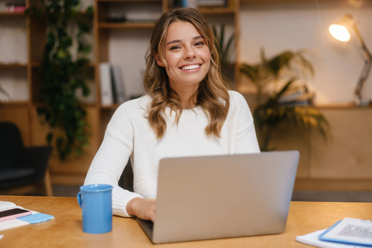 Erfolgreiche junge Geschäftsfrau, die im Büro an ihrem Laptop arbeitet.