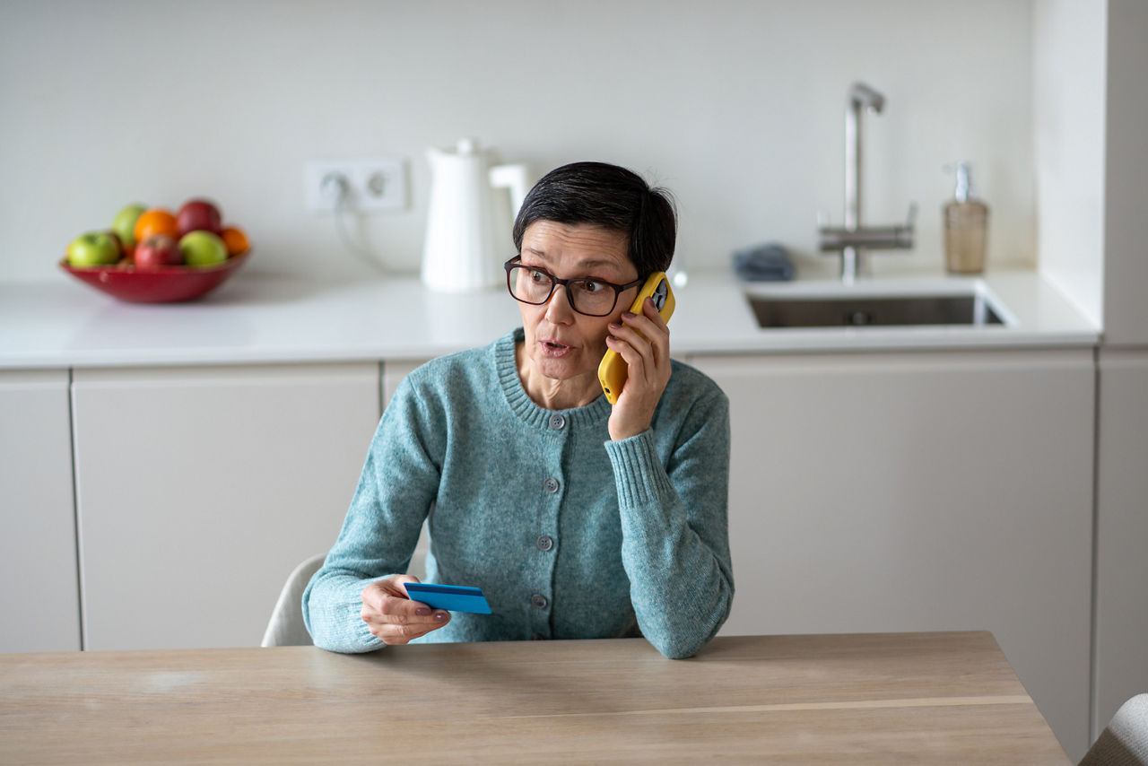 Frau telefoniert am Esstisch