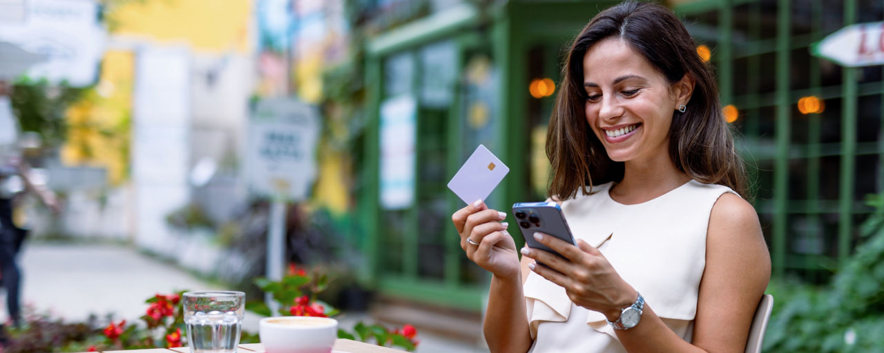 Eine Person hält eine girocard (Debitkarte) vor ein Kartenlesegerät