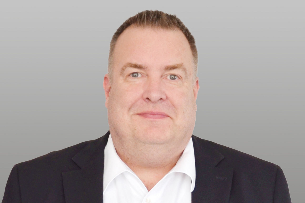 Privatkundenberater Frank Bieber vor grauen Hintergrund