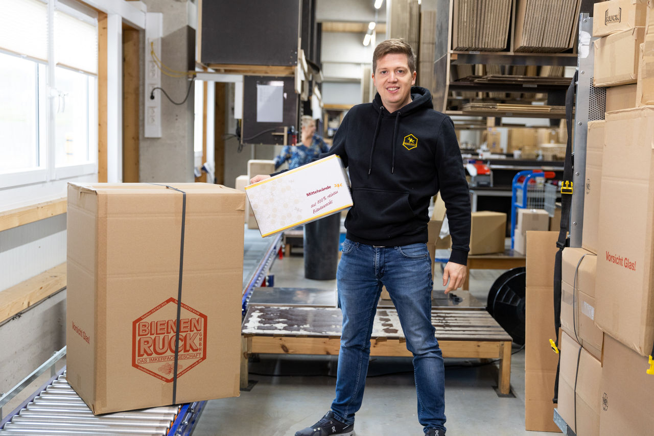 Inhaber Daniel Ruck im Versand von Bienen Ruck beim Verpacken und Bereitstellen von Imkereiprodukten.