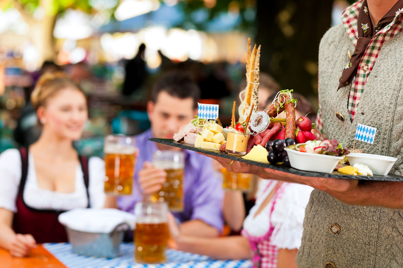 In Beer garden in Bavaria, Germany - beer and snacks are served, focus on meal