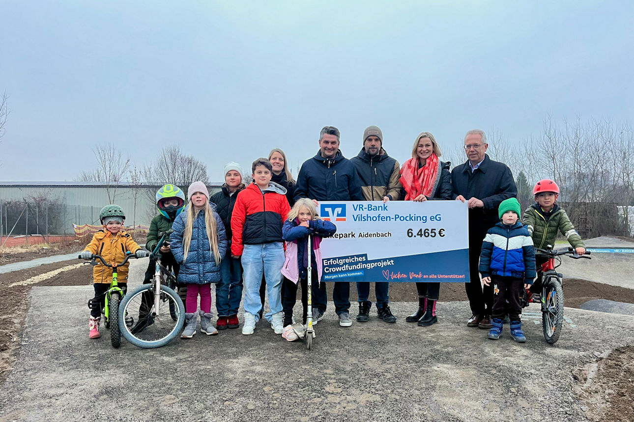 Die Verantwortlichen des Projektes mit einer Mitarbeiterin der Bank bei der symbolischen Scheckübergabe