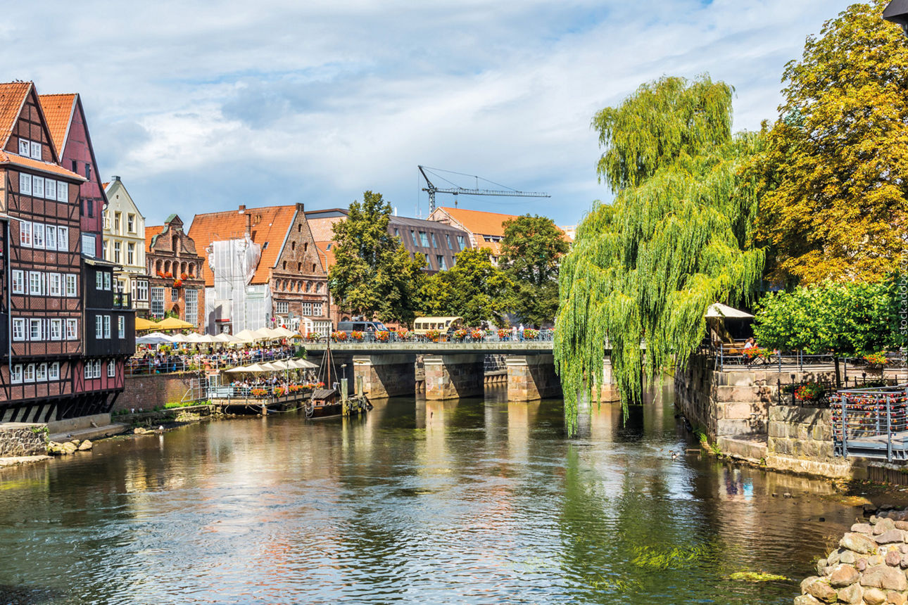 Fluß durch Lüneburg mit Häusern auf der linken Seite und einer Brücke