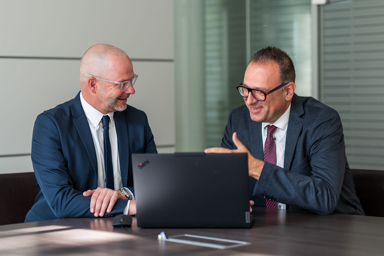 Axel Kiessling und Fabian Jäger sitzen an einem Tisch und unterhalten sich 