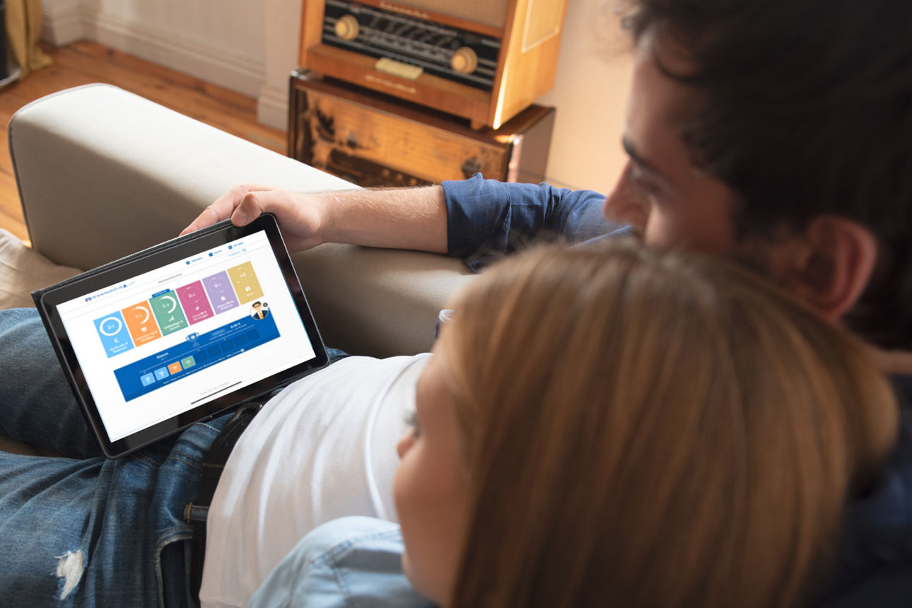 Ein Mann und eine Frau sitzen auf dem Sofa und schauen auf ein Tablet
