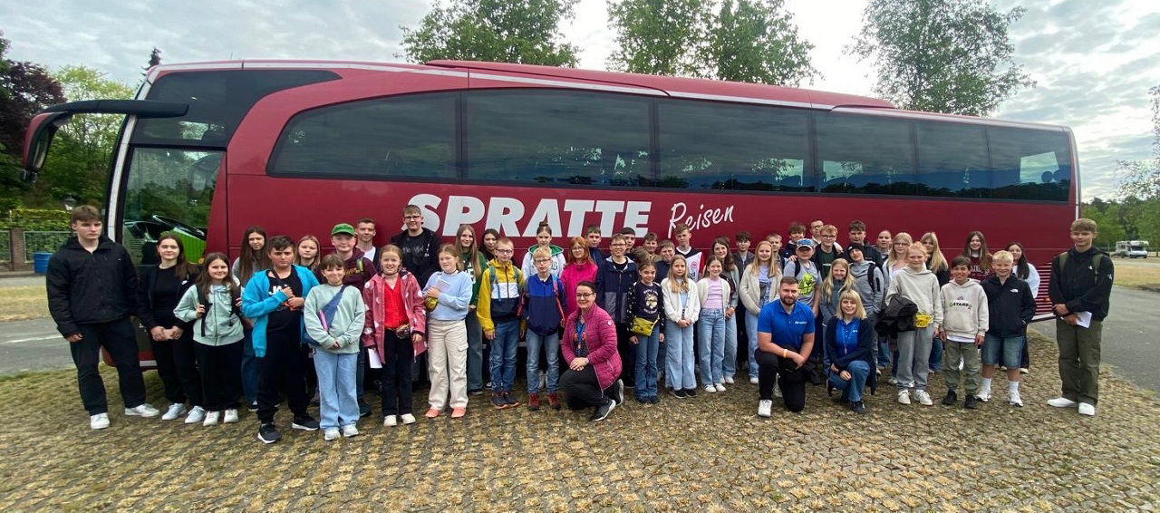 Kinder vor einem Bus. 