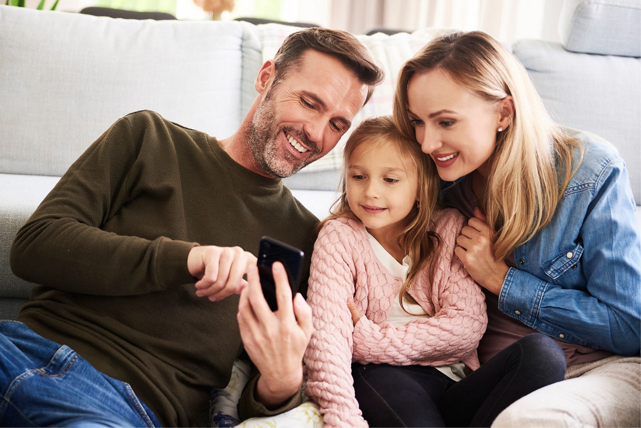 Familie schaut auf ein Handy