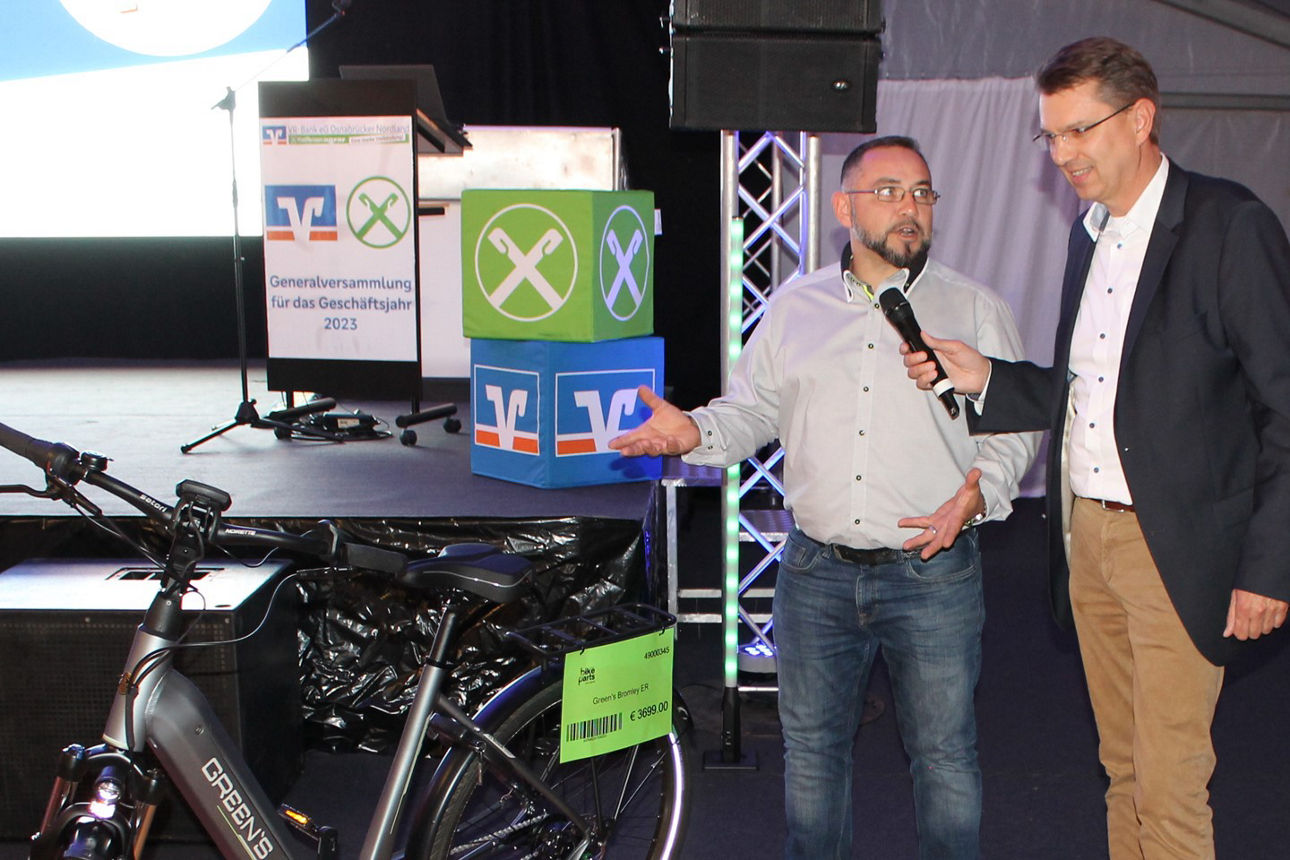 Zwei Männer stehen neben einem Fahrrad