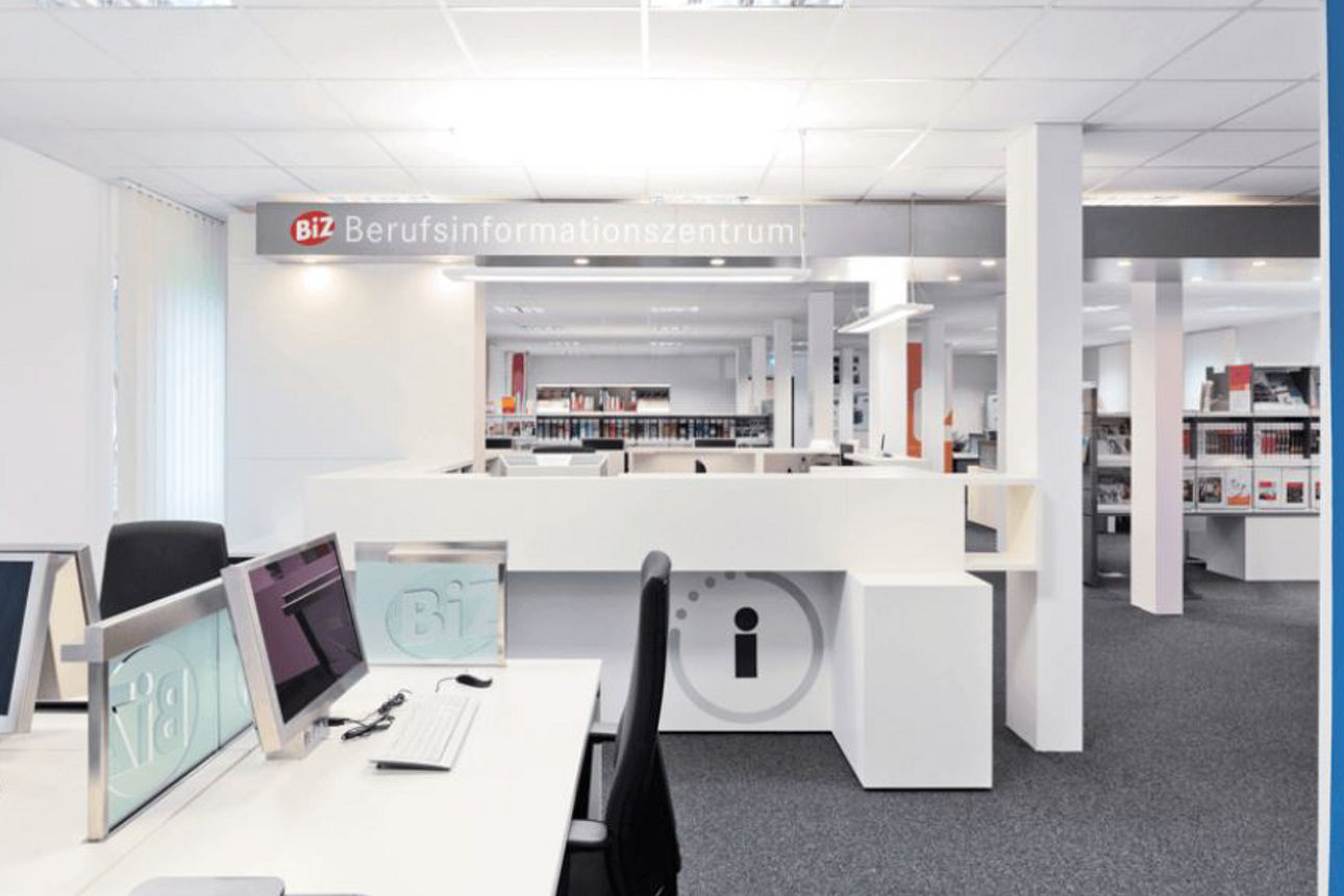 Offener Beratungsbereich mit Arbeitsplätzen und Hinweis auf Bewerbungsbereich.