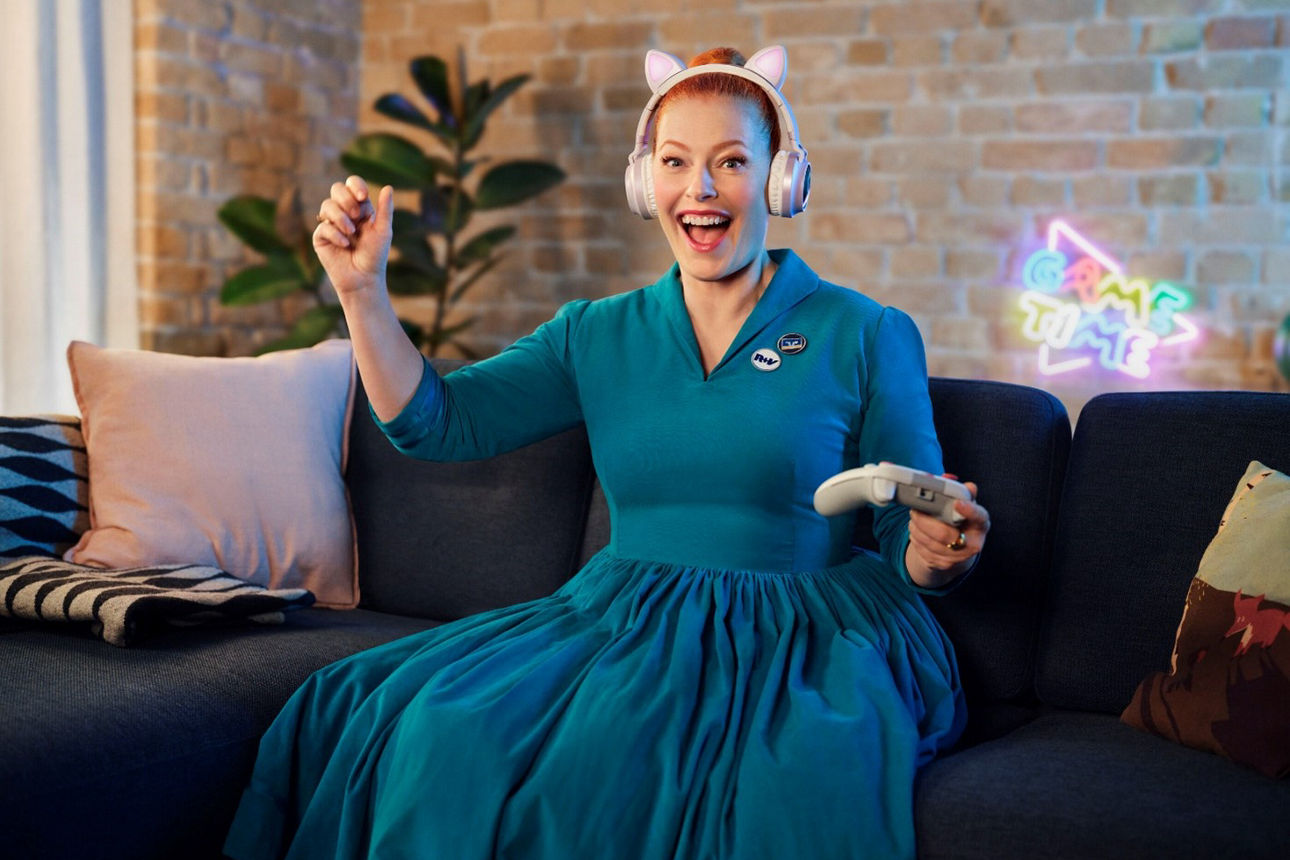 Frau mit Controller auf dem Sofa.