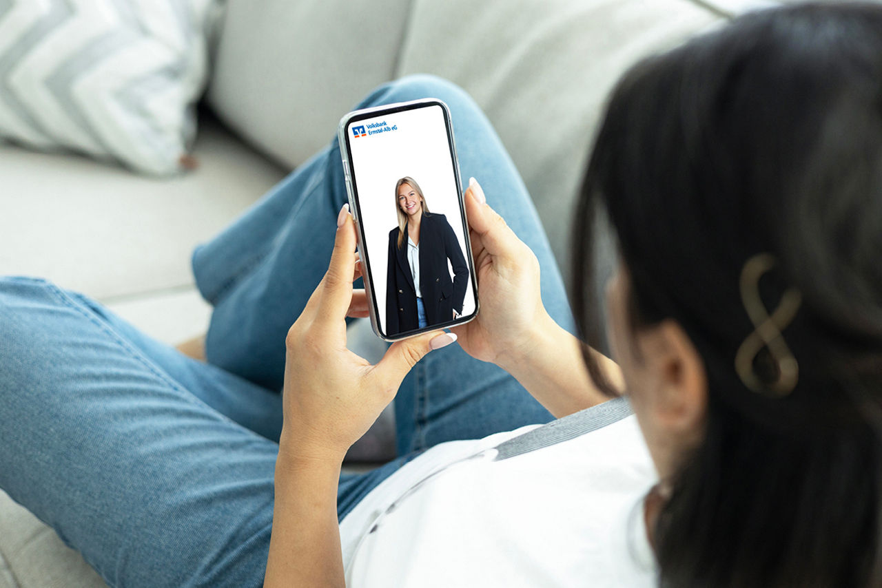 Frau liegt auf dem Sofa mit dem Handy bei der Digitalberatung