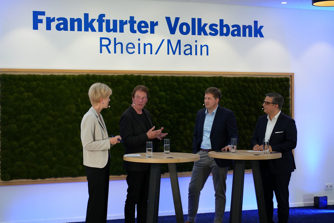 Drei Männer und eine Frau sind in einem Interview