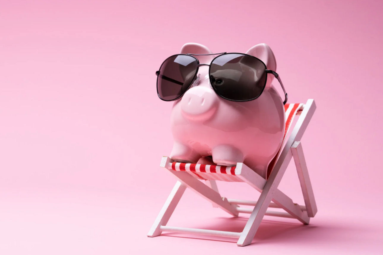 Sparschwein mit Sonnenbrille im Liegestuhl