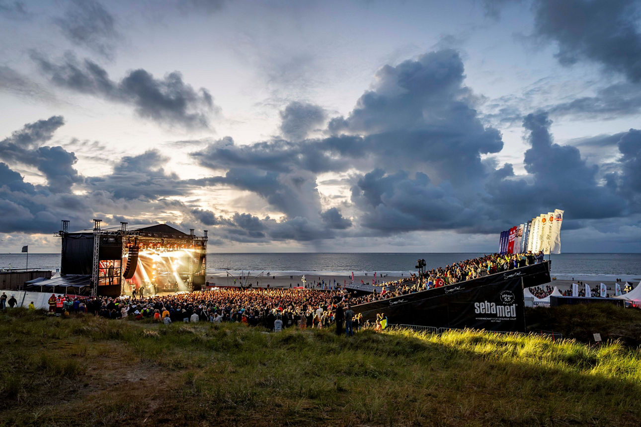 Bild von der beleuchteten Summertime-Bühne mit Publikum bei Nacht auf Norderney