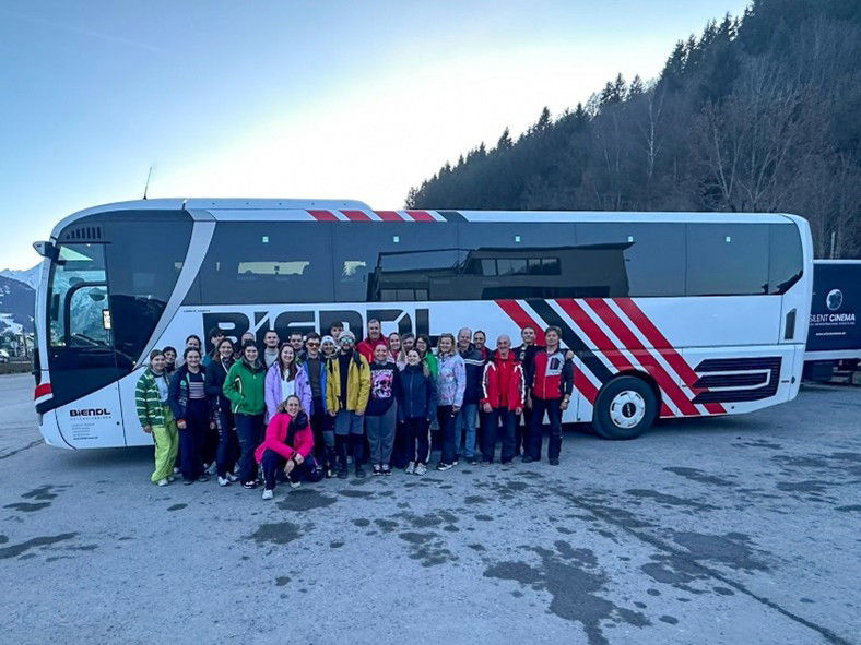 Ein Bus, davor eine Gruppe von Personen.auf der Schmittenhöhe. 
