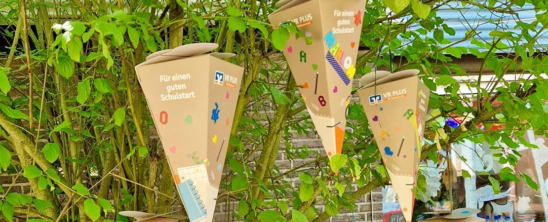 Schultüten hängen an einem Baum. 