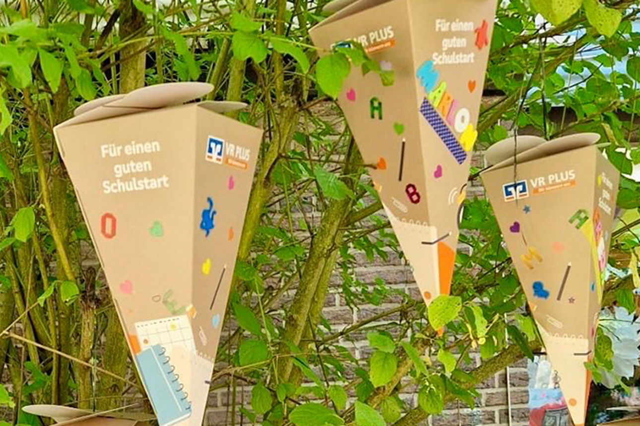 Schultüten hängen an einem Baum. 