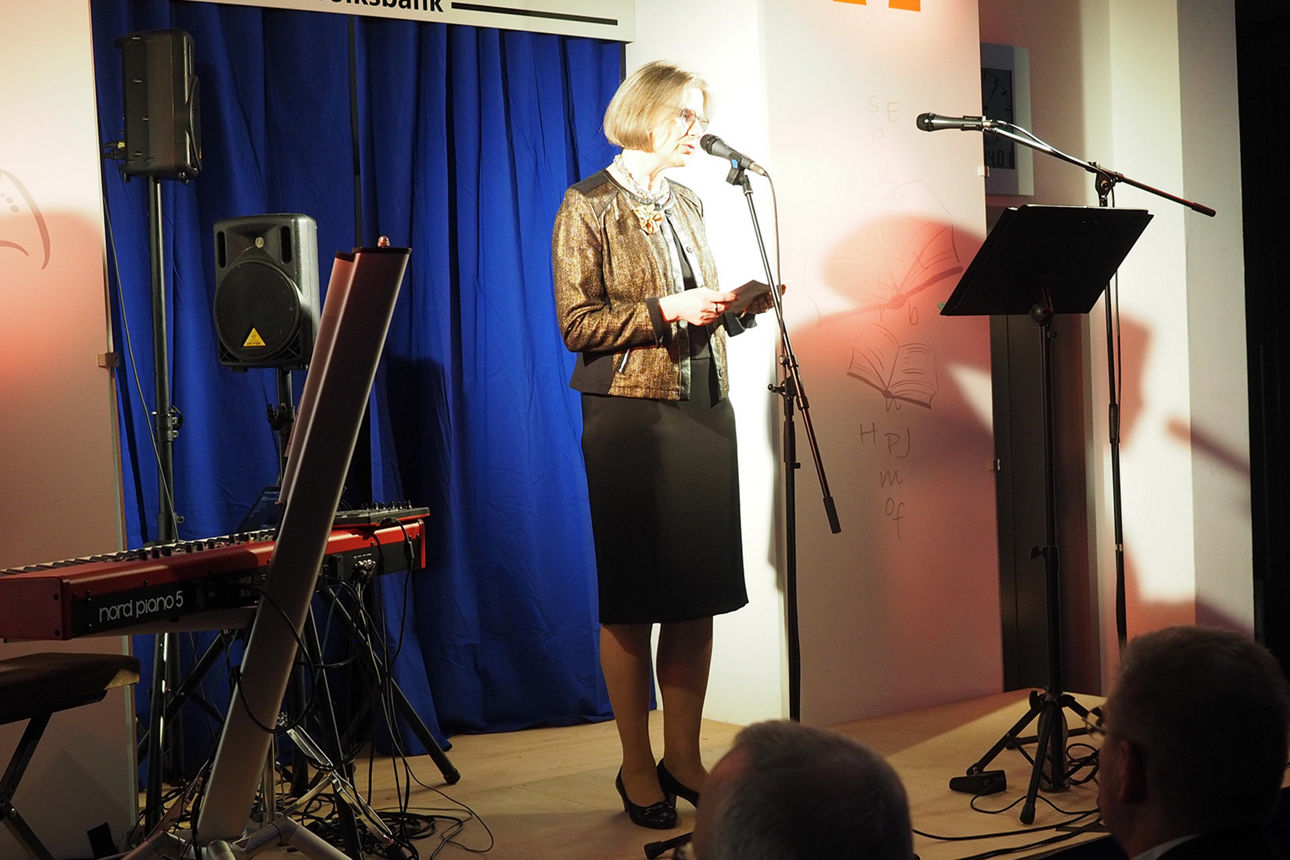 Bankdirketorin Karin Fleischer steht zur Begrüßung auf der Bühne