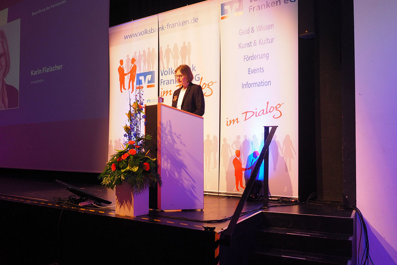 Bankdirektorin Karin Fleischer steht an einem Rednerpult auf der Bühne