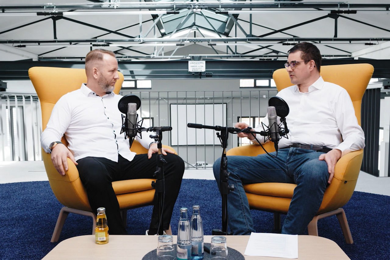 Zwei Personen reden in einem Podcast miteinander