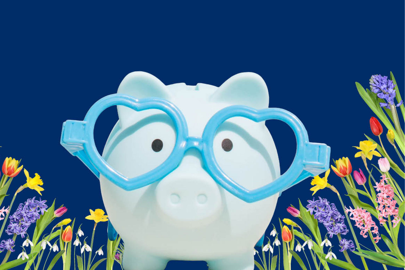 Blaues Sparschwein mit Herzbrille auf Blumenwiese