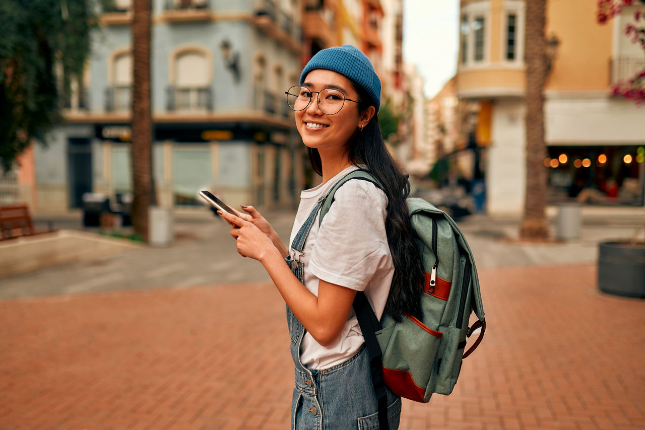Junge Frau mit Rucksack und Smartphone