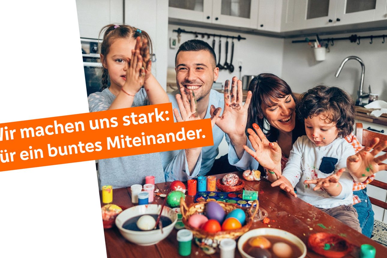 Glückliche Familie beim Färben von Ostereiern am Küchentisch