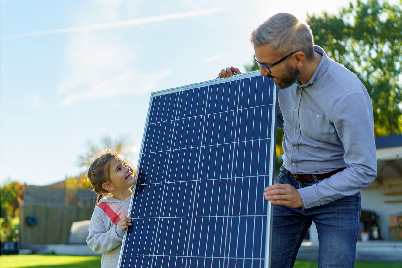 VobaCredit+ - Ein Vater hält mit seiner Tochter ein Photovoltaikpanel