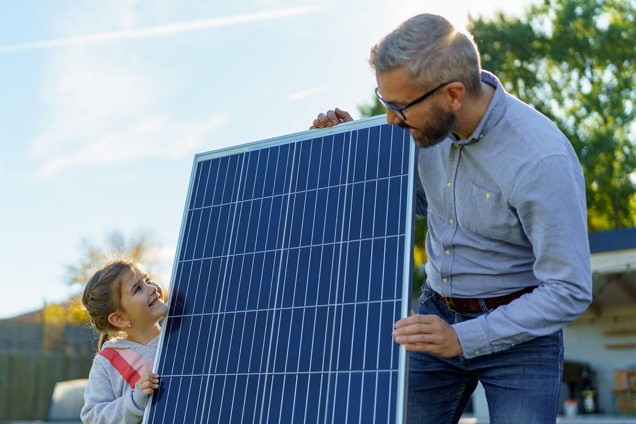 VobaCredit+ - Ein Vater hält mit seiner Tochter ein Photovoltaikpanel