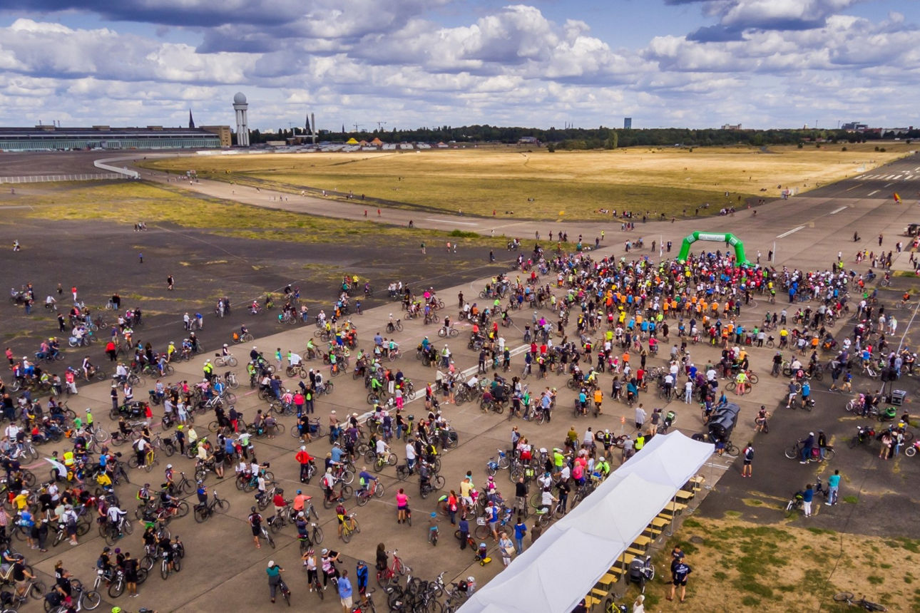 Luftaufnahme zeigt hunderte Radfahrende auf dem Tempelhofer Feld