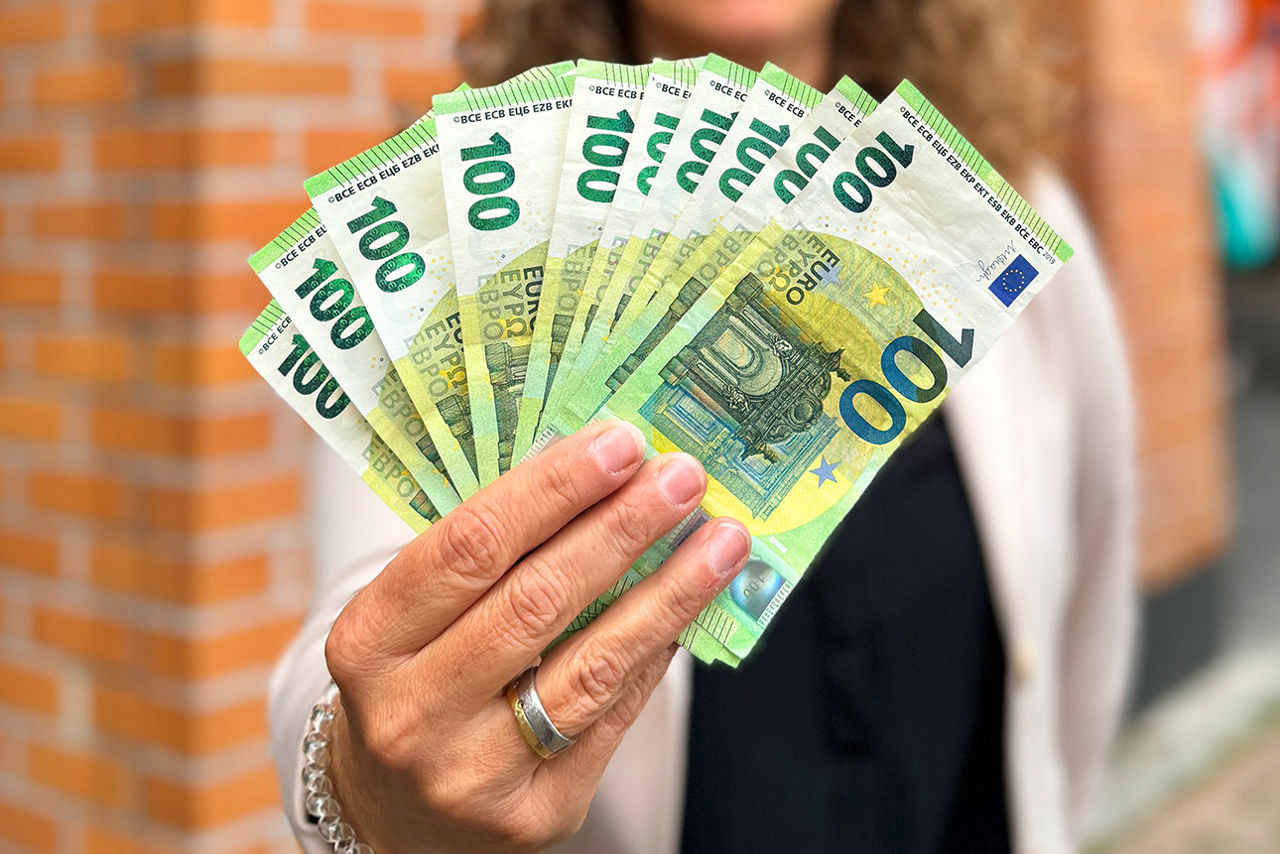 Geldbündel wird in die Kamera gehalten