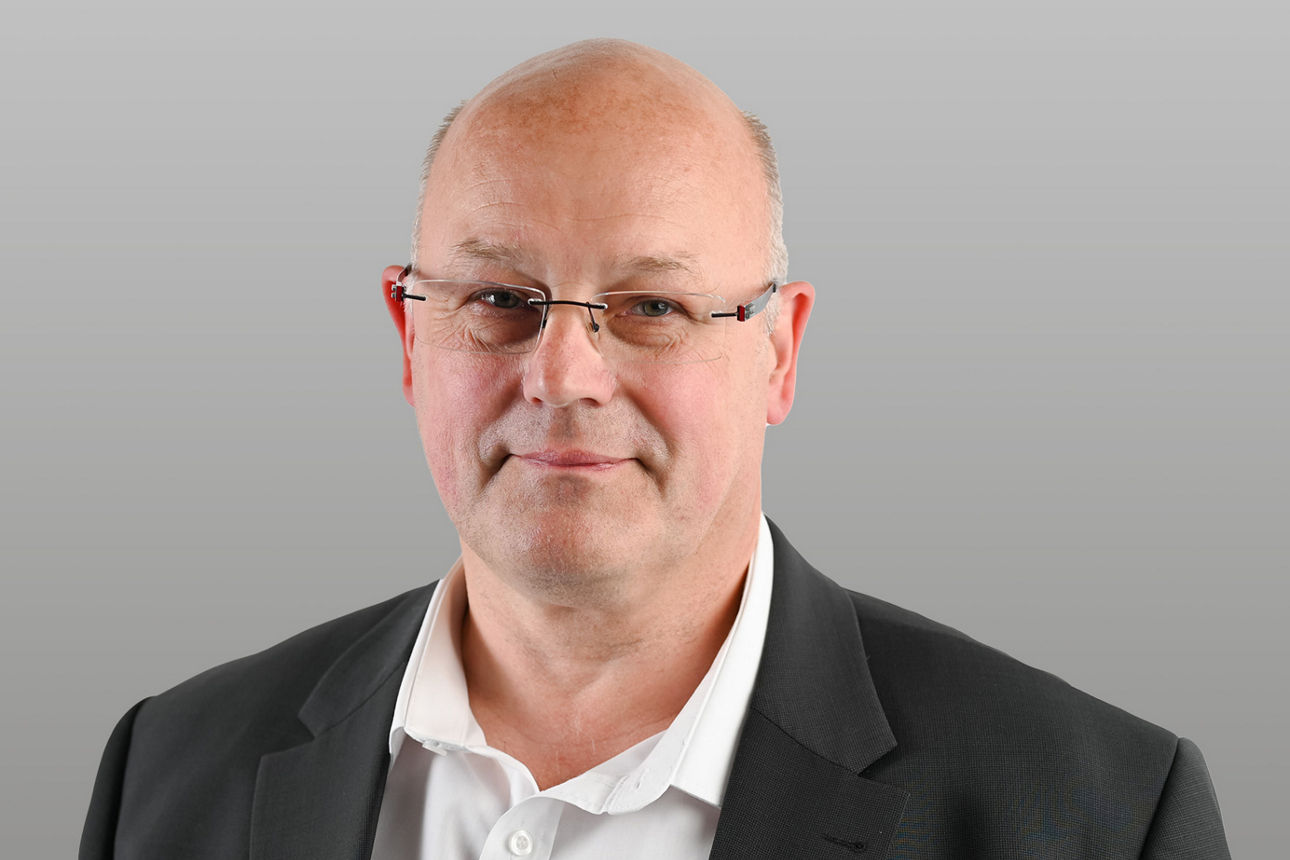 Privatkundenberater Reinhard Bingel vor grauen Hintergrund