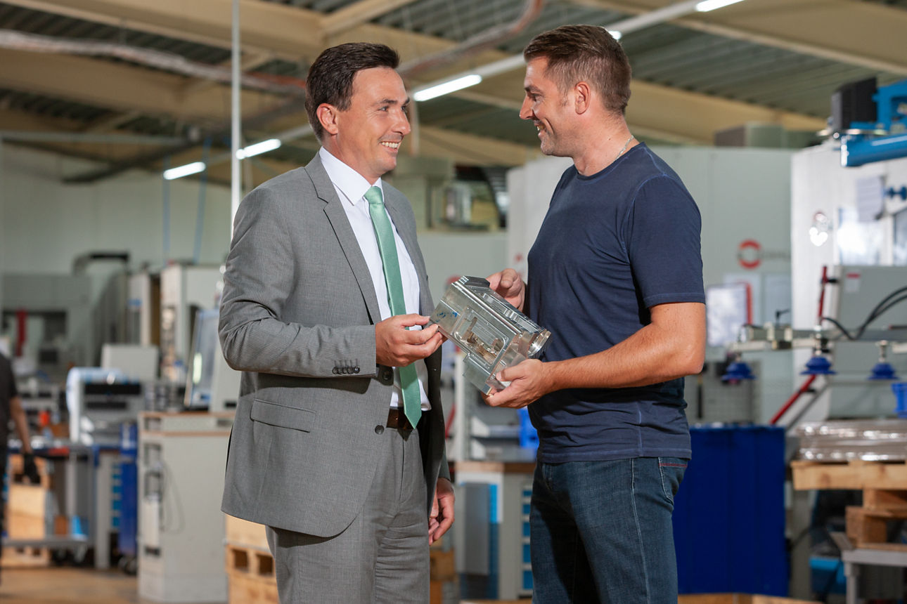 Zwei Männer stehen in einer Fabrik