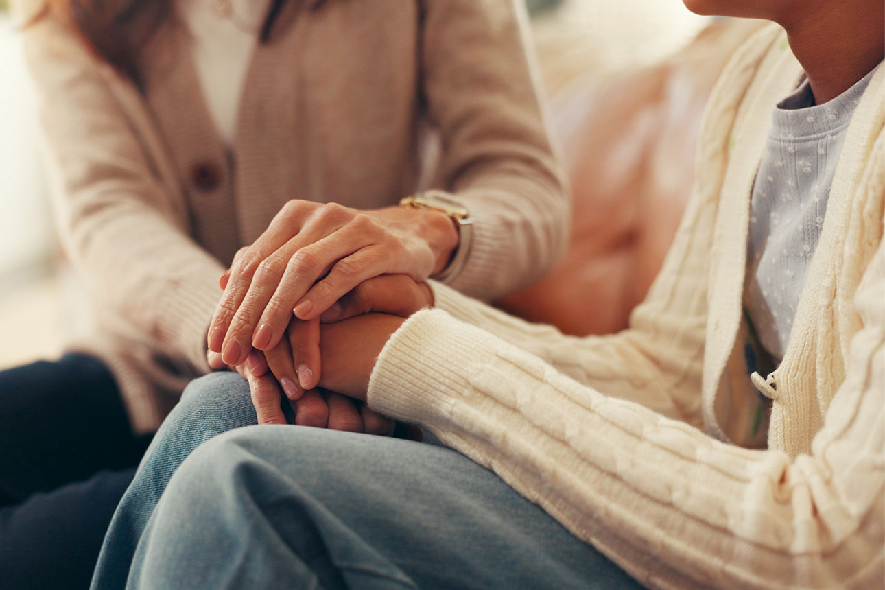 Eine Mutter und ihre Tochter halten sich an den Händen