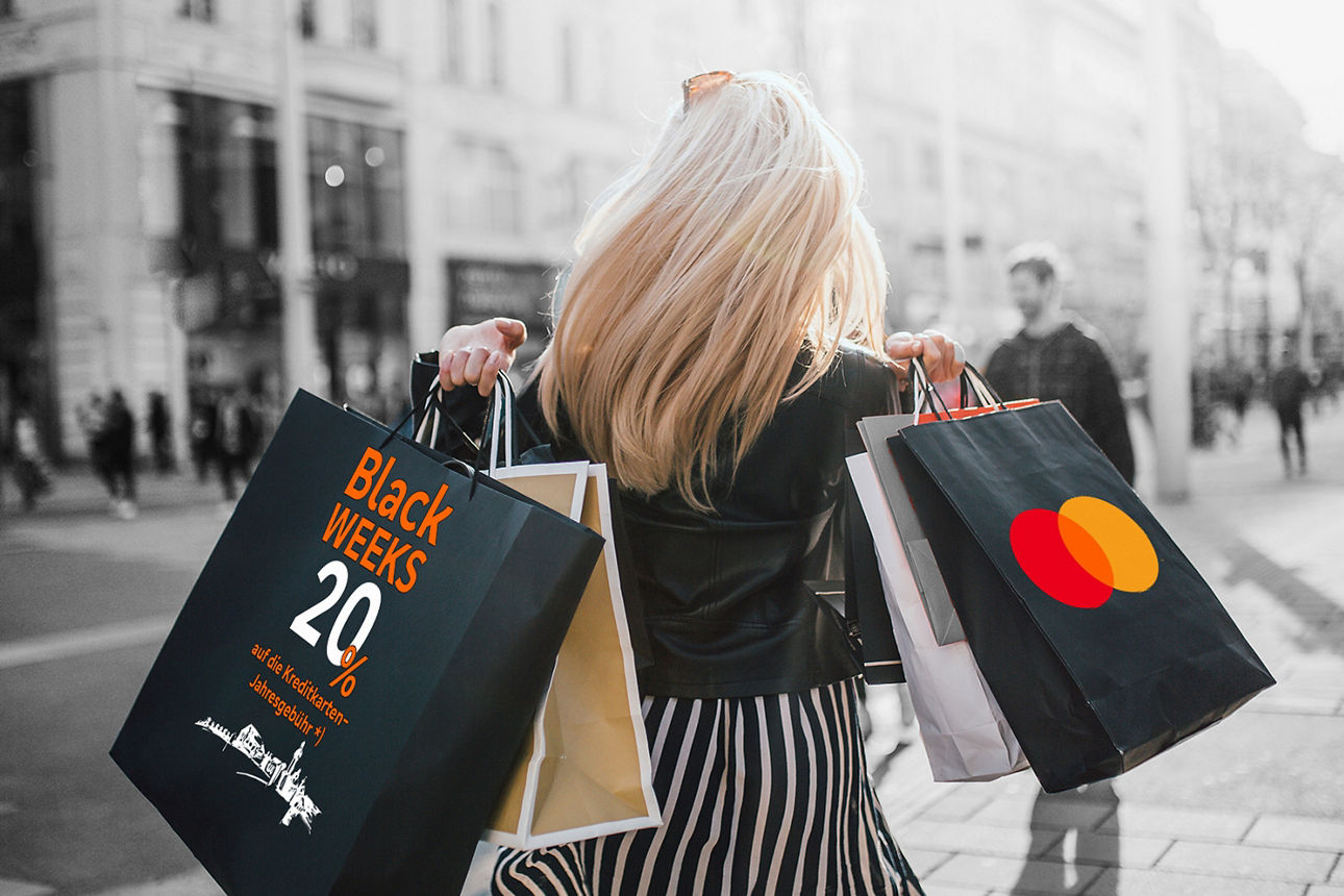 Eine Frau von hinten trägt Einkaufstaschen