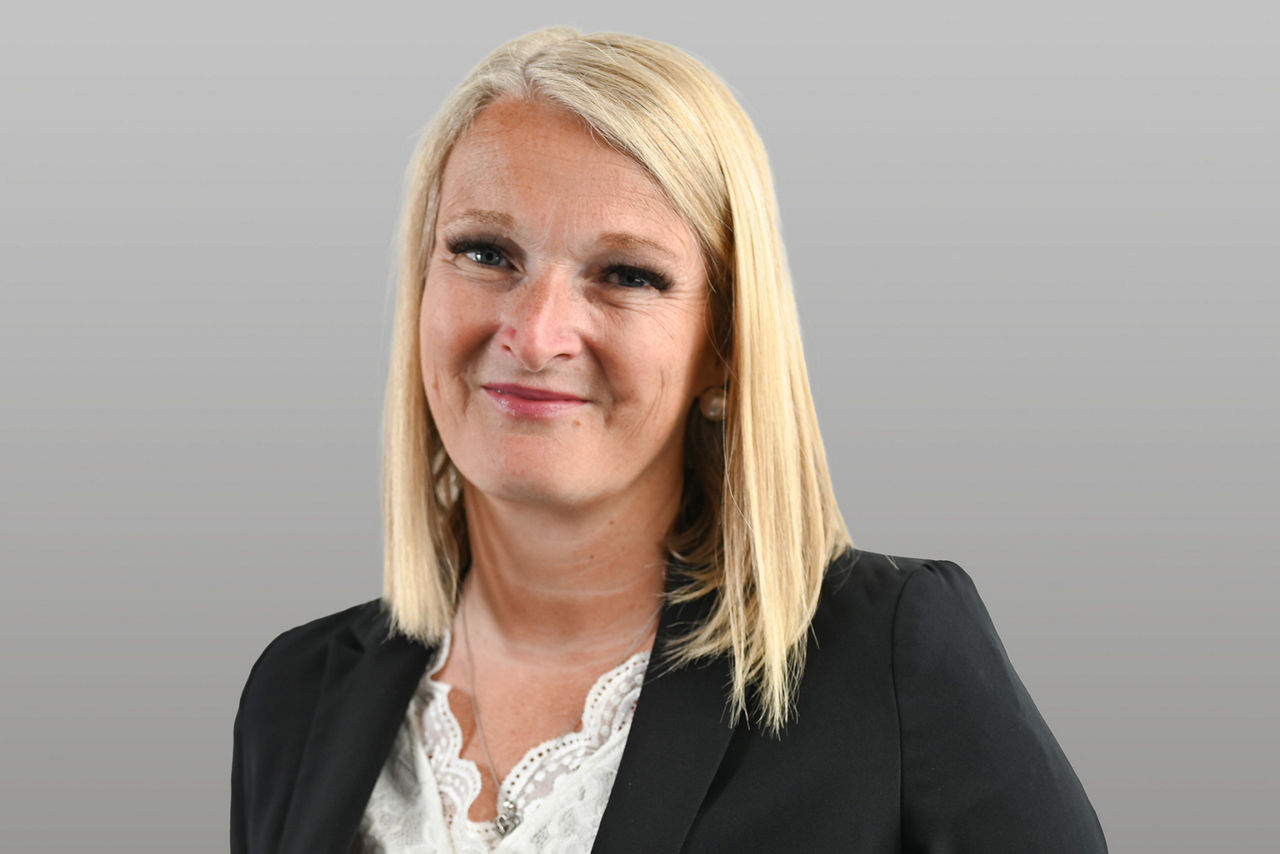 Privatkundenberaterin Claudia Blind vor grauen Hintergrund