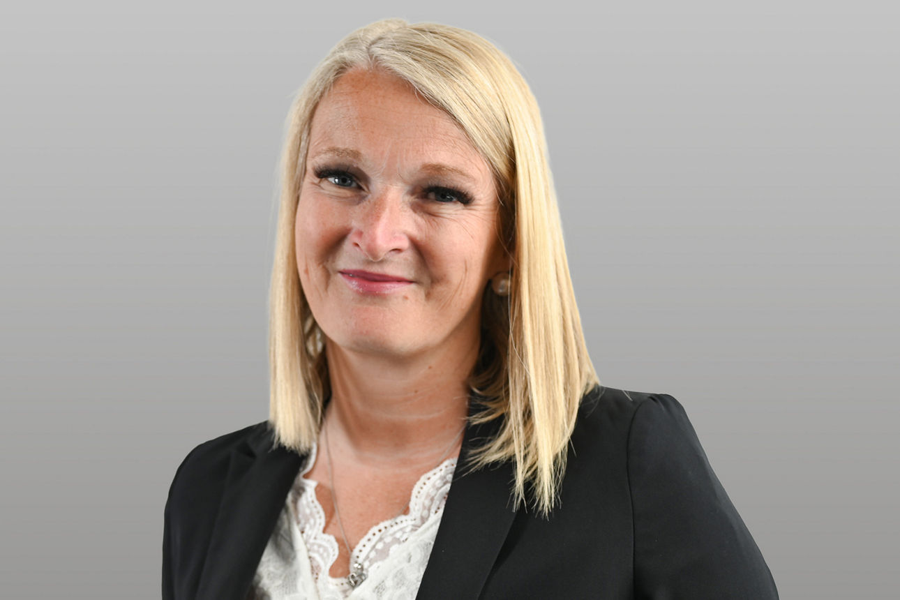 Privatkundenberaterin Claudia Blind vor grauen Hintergrund
