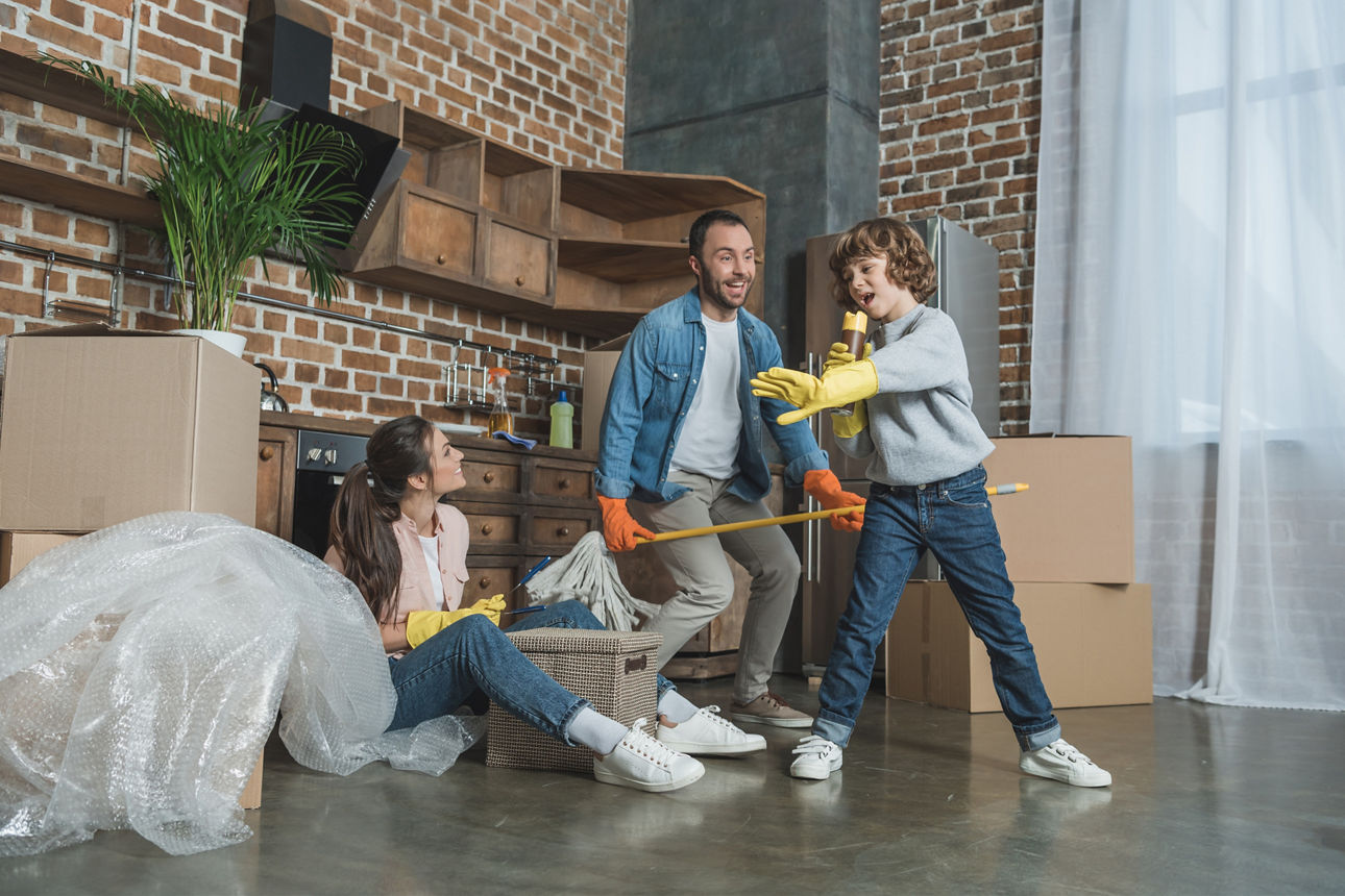 Mann, Frau und Sohn simultieren eine Band mit Putzlappen und Feudel