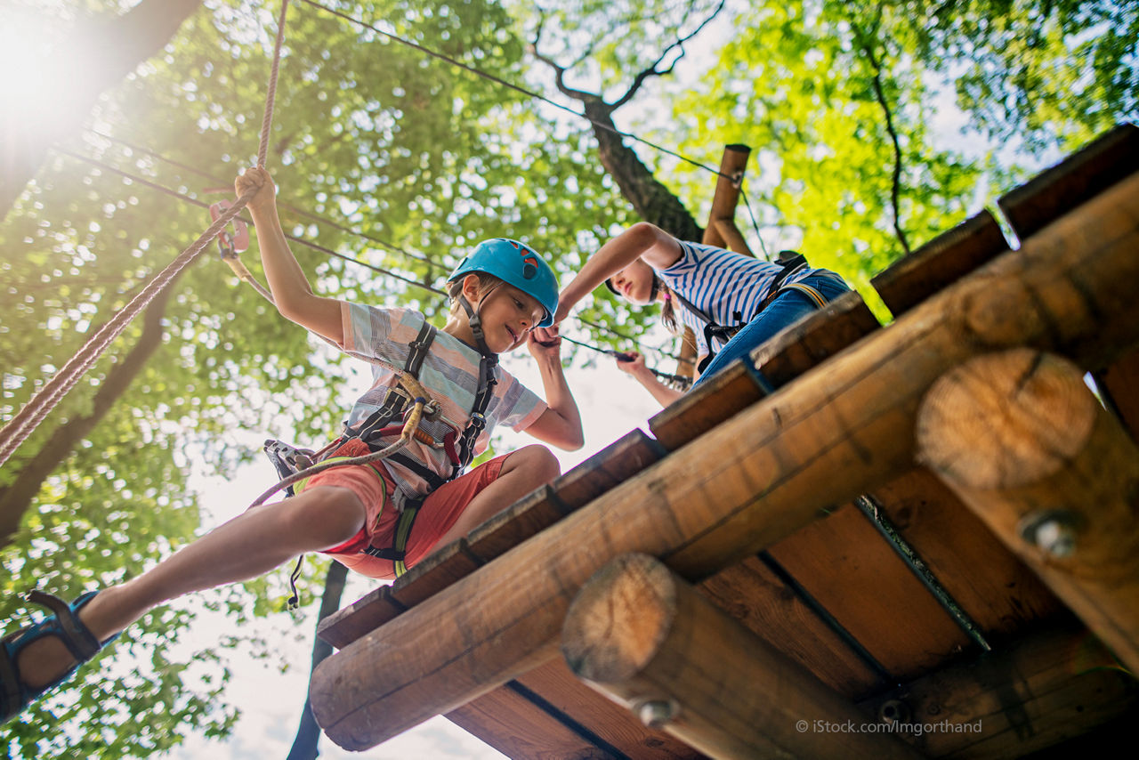 KollaZwei Kinder kleittern im Hochseilgarten