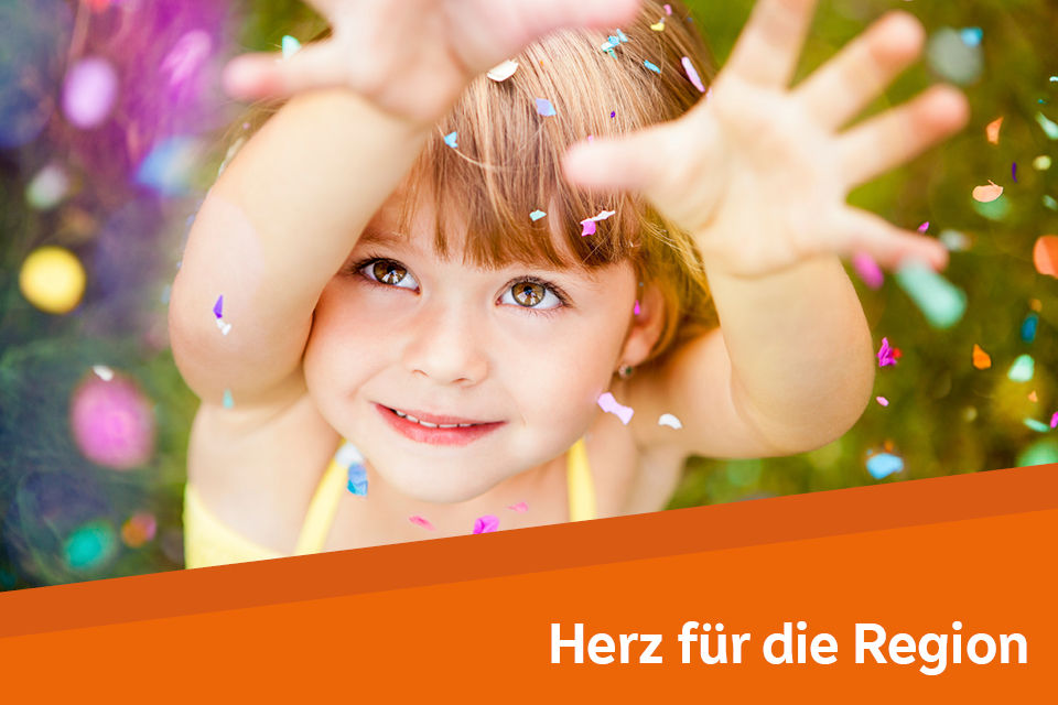 Kind schaut nach oben und greift nach Konfetti