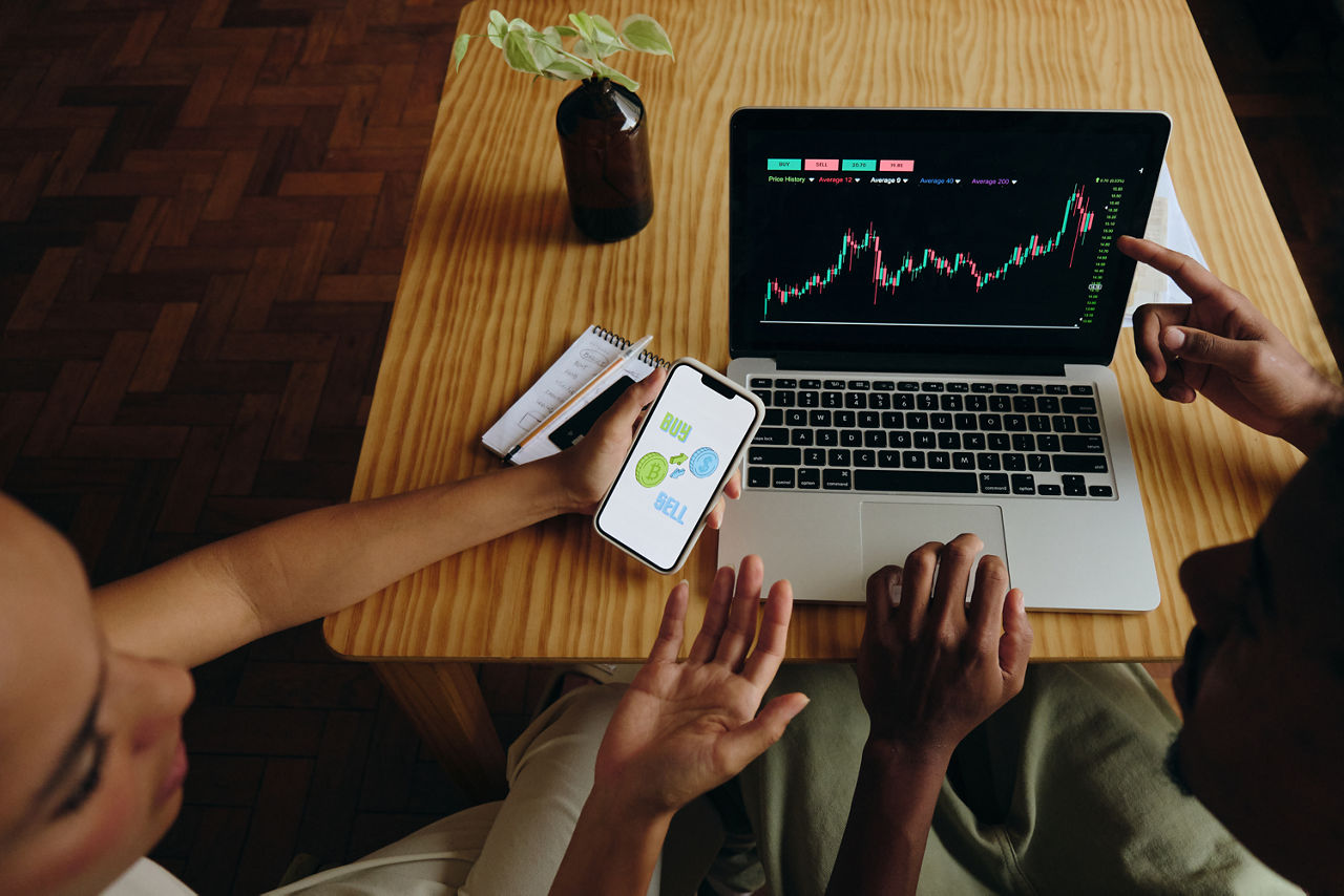 Frau und Mann vor Laptop mit DAX-Chart