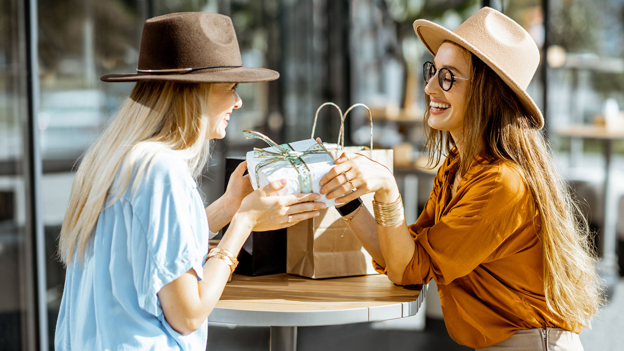 Zwei junge Frauen übergeben Geschenke