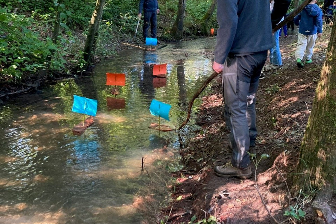 Ranger schaut den Booten auf dem Flüsschen hinterher
