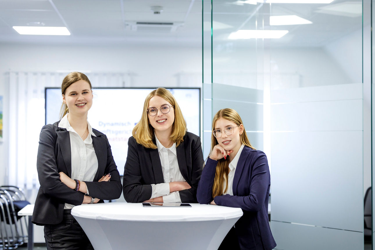 Drei weibliche Auszubildende der Bopfinger Bank Sechta-Ries eG lehnen sich an einen Stehtisch und schauen in die Kamera