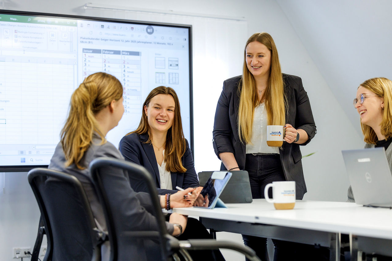 4 junge Frauen sitzen am Tisch und unterhalten sich 