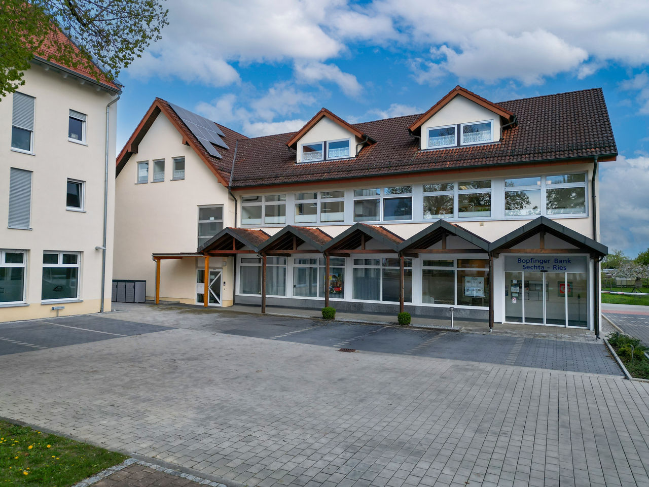 Luftaufnahme von einem Bankgebäude mit Parkplätzen davor